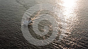 Top Aerial view moving fishing boat ocean. sailing motor boat with angler on Dnipro river at sunrise sunset. landscape