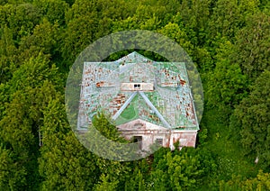 Top aerial view shot of abandoned building in impassable dense green forest. photo