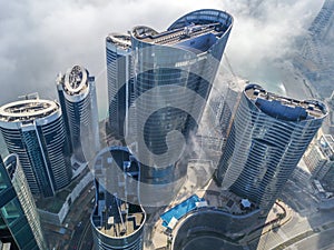 Top aerial view shot of skyscrapers in the city with fog clouds passing by - Abu Dhabi Al Reem island towers