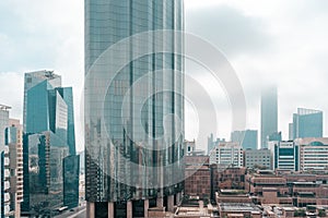 Top aerial view shot of skyscrapers in a modern city with fog clouds passing by - Downtown Abu Dhabi landmarks and World Trade Cen