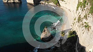 Top Aerial view of tropical beach, sea rocks, turquoise ocean and palm trees. Atuh beach, Nusa Penida island, Bali