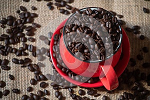 Top angle view of red coffee cup full of coffee beans