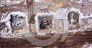 Top ascending aerial view of a foundation of a frame house in winter and working laborers. Snowy day