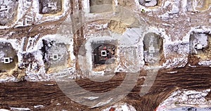 Top ascending aerial view of a foundation of a frame house in winter and working laborers. Snowy day