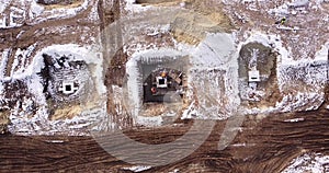 Top ascending aerial view of a foundation of a frame house in winter and working laborers. Snowy day