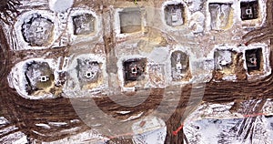 Top ascending aerial view of a foundation of a frame house in winter and working laborers. Snowy day