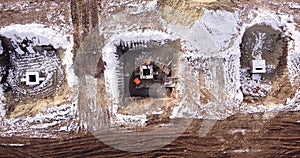 Top ascending aerial view of a foundation of a frame house in winter and working laborers. Snowy day