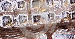 Top ascending aerial view of a foundation of a frame house in winter and working laborers. Snowy day