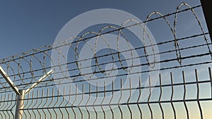 Top of barbed wire fence against sky, seamless loop