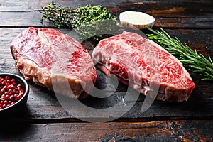 Top blade cut Steak or Feather steak raw meat over old wood table background. Side view