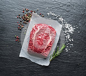 The top blade steak or beef steak on the graphite board with herbs and spices