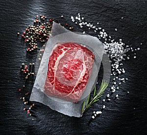 The top blade steak or beef steak on the graphite board with herbs and spices