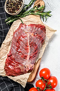 Top blade steak on a chopping Board, raw meat, marbled beef . Gray background. Top view