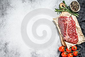 Top blade steak on a chopping Board, raw meat, marbled beef . Gray background. Top view. Copy space