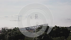 Top of the bridge stick out of the thick dense fog - people running marathon on the bridge