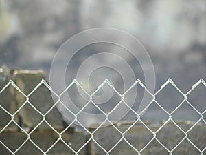 The top of a chain link fence. Behind it, a building recently destroyed by fire. Keeping out the curiosity seekers.