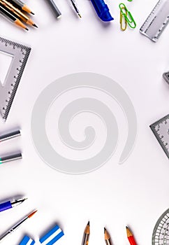 Top close up shot of geometrical instruments with pencils, eraser, binder clips and ruler on white surface