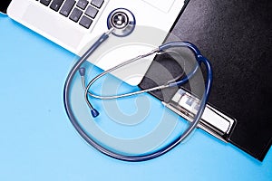 Top close up view of stethoscope next to a laptop