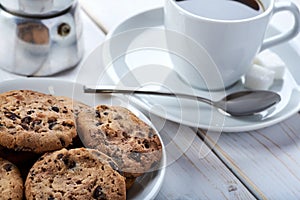 Top Closeup photo of sweet breakfast or snacks. Chocolate and vanilla cookies and cup of black coffee