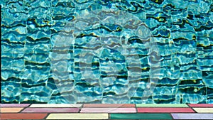 Top of colorful brick in front of water ripple pattern in pool