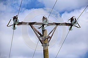 Top of concrete electricity pole with glass isolators on metal crown