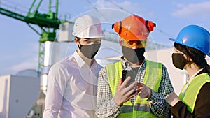 Top of construction site closeup to the camera in the pandemic of Coronavirus group of diverse specialists in