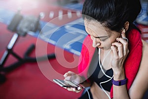 Top cropped shot portrait of a beautiful sporty young woman listening to music from her smartphone, having a break after workout