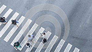 the From the top crosswise view of people walk on street pedestrian crossroad in the city street ,bird eye view. photo