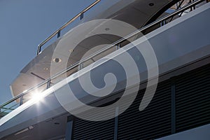 The top deck of a huge yacht at sunny day, glossy board of the boat, The chrome plated handrail, megayacht is moored in