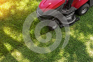 Top down above view of professional lawn mower worker cutting fresh green grass with landcaping tractor equipment