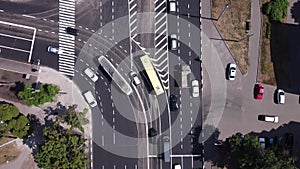 Top down aerial of cars drive at crossroad. City traffic on intersection.