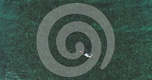 Top down aerial shot on surfers catching waves at the ocean. Bird eye view high on seawater with surfing board at the