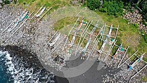 Top down aerial of traditional jukung boats resting on beach in Bali. Amed beach in Bali Indonesia with Jukung fishing