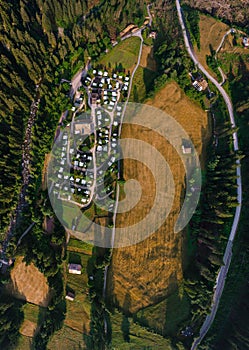 Top down aerial view of a camping site, recreation with a tent and parking for a motor home, camper van, harvested field,