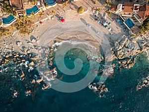 Top down aerial view of Conchas Chinas Beach in Puerto Vallarta Mexico showing rocks, sand, water photo