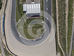 Top down aerial view of curve in motor sport race track circuit with sand roadside