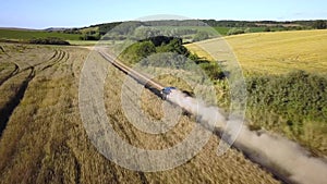 Top down aerial view of fast driving car on dirt road leaving cloud of dust behind.Top down aerial view of fast driving car on dir