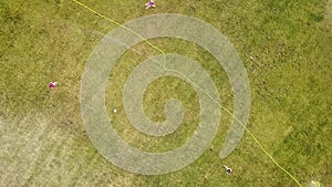 Top down aerial view of football field surface covered with green grass and sprinklers spraying water.