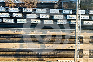 Top down aerial view of many cargo train cars on railway tracks