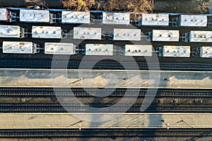 Top down aerial view of many cargo train cars on railway tracks