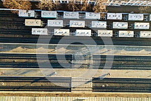 Top down aerial view of many cargo train cars on railway tracks