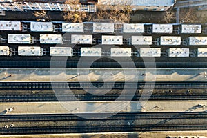 Top down aerial view of many cargo train cars on railway tracks