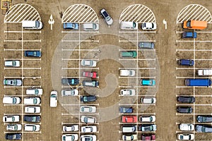 Top down aerial view of many cars on a parking lot of supermarket or on sale car dealer market