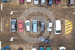 Top down aerial view of many cars on a parking lot of supermarket or on sale car dealer market