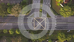 Top down aerial view of the road intersections with few vehicles moving in the morning. 4K.