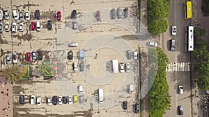 Top down aerial view of street with moving cars and zebra crosswalk with crossing pedestrians.