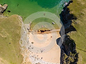 Top down aerial view of a tiny sandy beach and cove in West Wales Pembrokeshire