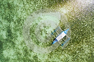 Top down aerial view of a tourist boat over a tropical coral reef in a clear ocean