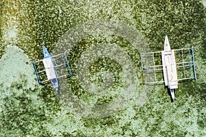 Top down aerial view of a two tourist boats over a tropical coral reef in a clear ocean