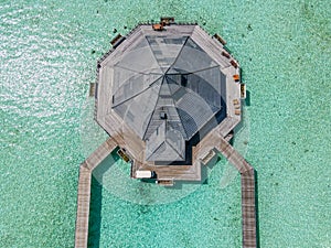 Top-down aerial view of the wooden over water hut at the tropical island
